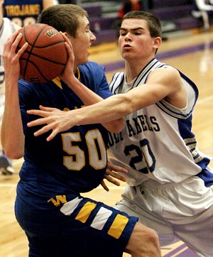 Junior forward Charlie Koontz of the Academy of Holy Angels in Richfield puts defensive pressure on senior guard Bradley Carlson of Wayzata High School during the championship game of The Catholic Spirit Christmas Basketball Tournament. (Dave Hrbacek / The Catholic Spirit)