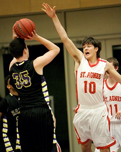Junior center Jack Fossand of St. Agnes High School in St. Paul tries to block a shot by sophomore center Francis Delaney of Cretin-Derham Hall during first-round action of The Catholic Spirit Christmas Basketball Tournament Dec. 27 at the University of St. Thomas. Cretin-Derham Hall won the game, 74-59.