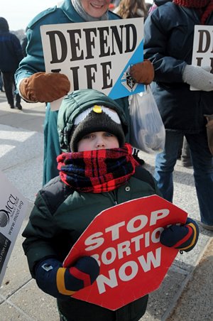 Joseph Curren from Divine Mercy in Faribault bundled up to attend the rally with his mom and grandma. (Dianne Towalski/The Catholic Spirit)