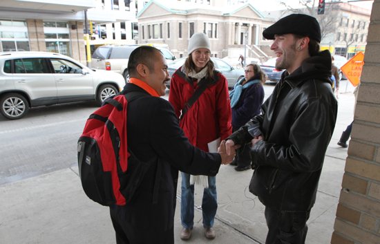 Rogelio Aguilar, left, and Katy O’Brien of St. Stephen in Minneapolis greet Chris Fisher at a bus stop on Hennepin Avenue in the Uptown area of Minneapolis March 23 as part of the parish Easter Mission, in which missionaries go out on the streets to evangelize in the nearby neighborhoods. Dave Hrbacek / The Catholic Spirit