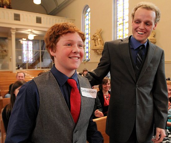 Zach Sobiech, right, of St. Michael in Stillwater, offers a gesture of congratulations to Matt Brown during Brown’s confirmation Mass at St. Mary in Stillwater April 22. Sobiech, a friend of the Brown family since his early years, died of cancer May 20 at his home in Lakeland. He was Matt’s confirmation sponsor. Dave Hrbacek / The Catholic Spirit