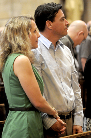 Anne and Robb Turner, members of both St. John Neumann in Eagan and St. Joseph in Rosemount, who celebrated their 17th anniversary on June 8, held hands as they listened to Archbishop Niensted’s homily during the Archdiocesan Marriage Day celebration.