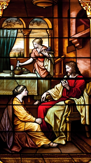 A stained glass window shows Jesus, Martha and Mary. Bigstockphoto.com