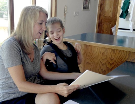 Debi Moffatt helps her daughter Jennifer prepare for confirmation class. Jennifer and her brothers Patrick and Daniel will be confirmed Sept. 8 at the annual Mass for Persons with Disabilities. Dianne Towalski / The Catholic Spirit