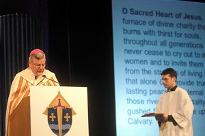 Archbishop John Nienstedt consecrates the archdiocese to the Sacred Heart of Jesus and the Immaculate Heart of Mary during the 2013 Rediscover: Catholic Celebration. At right is Father John Paul Erickson, director of the archdiocesan Office of Worship. (Dianne Towalski/The Catholic Spirit)