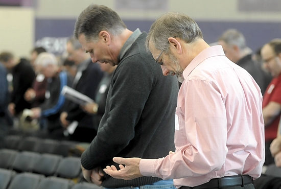 John Sprangers, left, a member of Transfiguration in Oakdale and John Bartunek, who attends North Heights Lutheran in Roseville, bow their heads for the blessing during the Mass at the Archdiocesan Men’s Conference March 22 at the University of St. Thomas.