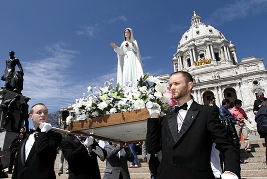 With the State Capitol as a backdrop, Matthew Vogel, left, of St. Joseph in West St. Paul and Karl Hendrickson of Holy Trinity in South St. Paul help carry a statue of Mary at the start of the 67th annual Archdiocesan Family Rosary Procession May 4. The procession went from the capitol to the Cathedral of St. Paul, with Bishop Lee Piché walking with the marchers. The event also featured parts of the rosary in Spanish, with Latino Catholics joining in and members of Our Lady of Guadalupe in St. Paul helping to carry the statue of Mary. Dave Hrbacek/The Catholic Spirit