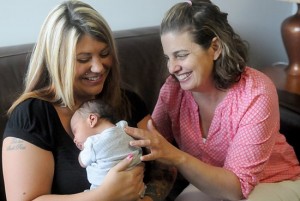 Kristin Wermus, right, a master-certified life coach and client services director, visits with Aleesha Warner and her 2-week-old son Jayden at Pregnancy Choices in Apple Valley in this 2014 file photo. Dianne Towalski / The Catholic Spirit.
