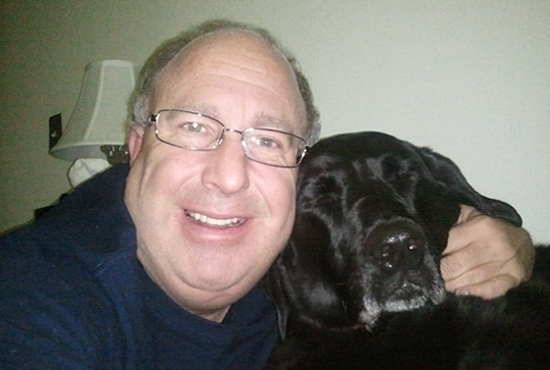 Brother Paul O'Donnell poses with Rocky, one of two Labrador retrievers he and the brothers received in 2003 as a gift from friends Nicole and Ryan Selleck. Dave Hrbacek/The Catholic Spirit