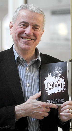 University of St. Thomas psychology professor John Buri holds a copy of his book about dating. Dave Hrbacek/The Catholic Spirit