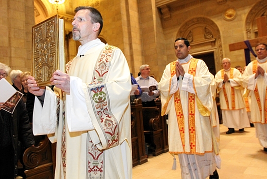 Deacon Joseph Michalak carries the Book of the Gospels March 26 at the Chrism Mass at the Cathedral of St. Paul. Dave Hrbacek/The Catholic Spirit