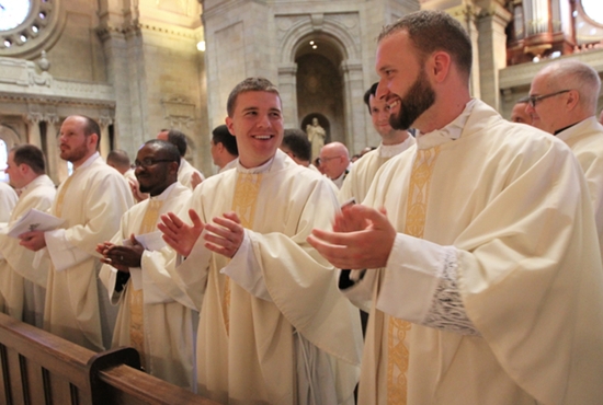 Newly ordained Fathers Peter Hughes, right, and James Stiles break out in smiles at the end of their ordination Mass May 30 at the Cathedral of St. Paul. Joining them in the front pew are Fathers John Powers, left, Thomas McKenzie and Bruno Nwachukwu. Others who were ordained that day are Fathers Jake Anderson, Byron Hagan and Alvaro Silva. Dave Hrbacek/The Catholic Spirit