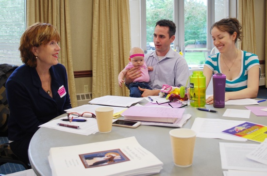 Deborah Savage, left, co-director of the University of St. Thomas’ Siena Symposium for Women, Family and Culture, and Jake and Shannon Voelker of St. Joseph in West St. Paul discuss St. John Paul II’s “Letter to Families.” Shannon is holding their daughter, Siena. Bridget Ryder/For The Catholic Spirit