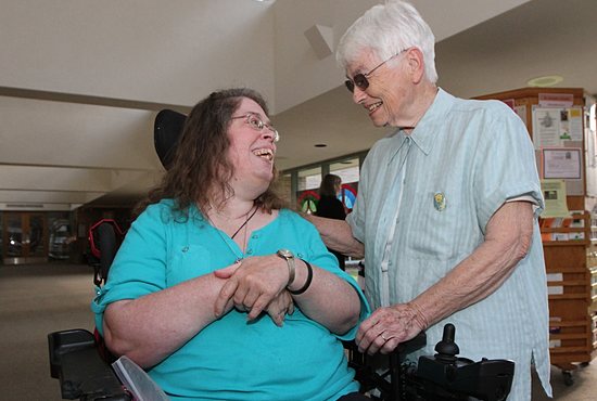 Terry Adamson, left, talks with Marcelle Diedrich before Mass Aug. 20 at St. Joseph in West St. Paul. “She lights up this church,” Diedrich said of Adamson, who goes to daily Mass several times a week. “Sometimes after Mass everybody has to take a number to talk to her. Everybody smiles when they see her.” Dave Hrbacek/The Catholic Spirit