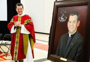 Father John Ubel admires a painting of himself that will hang in the new Ubel Activity Center at St. Agnes School in St. Paul. The former St. Agnes pastor and superintendent of the school was influential in saving St. Agnes from closing eight years ago. Mike Ekern photo