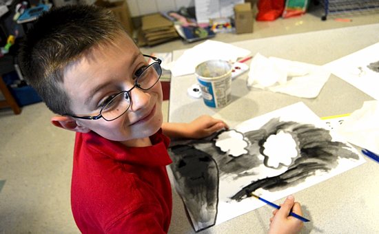 First-grader Jared Templin works on the clouds and the threatening sky portion of his watercolor painting of “God’s rainbow” at St. Joseph Catholic School in Waconia. The activity combines learning about colors with developing students’ creativity, teacher Mollie Olsen explained. Bob Zyskowski/The Catholic Spirit