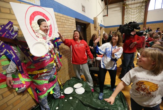 Physical education teacher Blair Benecke tries to endure whipped cream pies to the face at Nativity of Mary School in Bloomington Jan. 21. It was part of a fundraiser to raise money for children with leukemia.