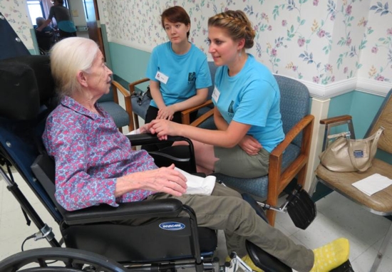 Stacey Jackson, front center, a graduate of Seton School in Manassas, Va., and Amy Endres speak with nursing home resident Kathleen Grace in early July during this summer’s pilot of SALT, a mission program hosted by the Carmelite Sisters for the Aged and Infirm. CNS photo/courtesy Carmelite Sisters for the Aged and Infirm