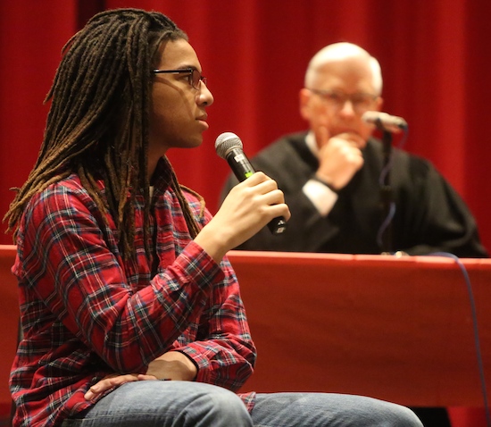 Benilde-St. Margaret’s senior Obasi Lewis plays a Roman centurion who is a witness in an event at the school called Jesus on Death Row: The Trial of Jesus and American Capital Punishment. In the background is Minnesota Supreme Court Justice David Lillehaug, who acted as judge in the trial. Dave Hrbacek/The Catholic Spirit