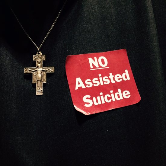 Brother Pio King, a Franciscan Brother of Peace, wears a red sticker March 16 to oppose a bill to legalize physician-assisted suicide in Minnesota. Maria Wiering/The Catholic Spirit