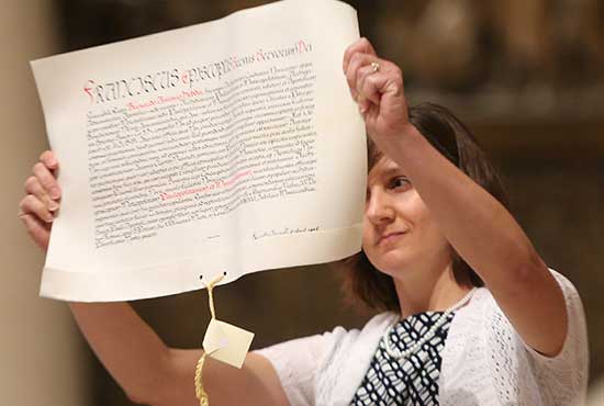 As part of the May 13 installation ritual, Susan Mulheron, archdiocesan chancellor for canonical affairs, presents Pope Francis’ mandate, the document in which the pope formally appoints Archbishop Bernard Hebda the new ordinary of St. Paul and Minneapolis. Dave Hrbacek/The Catholic Spirit