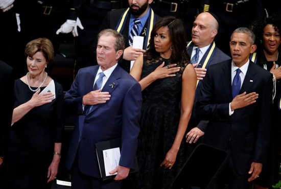 Former first lady Laura Bush, former U.S. President George W. Bush, first lady Michelle Obama and President Barack Obama hold their hands on their hearts as they sing the national anthem July 12 at a memorial service held in honor of police officers killed and wounded in shootings in Dallas. CNS photo/Carlo Allegri, Reuters