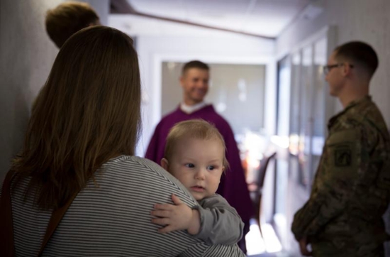 Army soldiers and military family members speak with Father Lukasz J. Willenberg following a March 7 Mass at one of the Catholic chapels at Fort Bragg in Fayetteville, N.C. Father Willenberg, who holds the rank of captain, is a U.S. Army chaplain at Fort Bragg and trains as a noncombat paratrooper with the 82nd Airborne Division. CNS photo/Chaz Muth