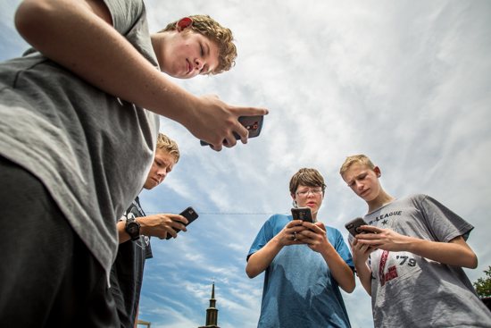 Alec Richardson, Brennan Moore, Adam Salman and Blake Koelz hunt Pokemon stops July 14 around the grounds of Assumption Church in St. Louis. CNS photo/Lisa Johnston, St. Louis Review