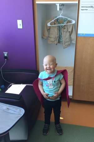 Leukemia patient Caroline Hoffman, who will soon celebrate her 4th birthday, sports a pint-size "super hero" cape crafted by eighth-graders at Sacred Heart of Jesus School in Baton Rouge, La. Caroline is a patient at Our Lady of the Lake Children's Hospital in Baton Rouge. CNS photo/courtesy of Sacred Heart of Jesus School