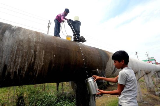 Indian boys collect drinking water in early May from the main water supply line in Bhopa. Allowing people to drink unsafe water or have no access to dependable, clean sources of water is shameful, Cardinal Peter Turkson told religious leaders at an interfaith meeting Aug. 29 in Stockholm. CNS photo/Sanjeev Gupta, EPA