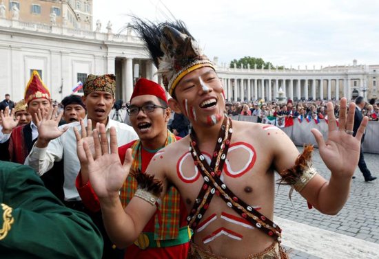 Pilgrims from Indonesia wave before Pope Francis arrives to lead his weekly audience Sept. 21 in St. Peter's Square at the Vatican. CNS photo/Remo Casilli, Reuters