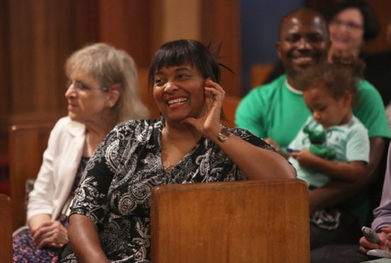 Lynette Graham, second from left, reacts to remarks by Archbishop Hebda during his homily. At left is Karen Johnson, wife of Deacon Johnson. At right is Brendan Banteh and his daughter, Charlotte, who belong to St. Peter Claver. Dave Hrbacek/The Catholic Spirit