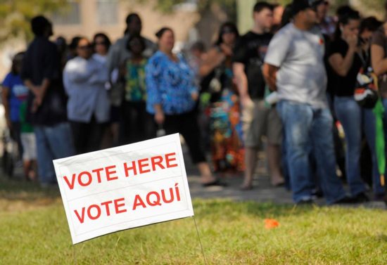 A sign in English and Spanish is seen as people wait to vote in 2012 outside a polling place in Kissimmee, Fla. A Pew Research Center poll released Oct. 10 shows Hispanic Americans give nearly a 5-1 edge to Democrats over Republicans as the party they feel is more concerned for them. CNS photo/Scott A. Miller, Reuters