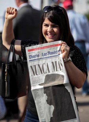 A woman gestures while holding a newspaper with a image of Cuban revolutionary leader Fidel Castro that reads in Spanish, "Never Again," a day after the announcement of the death of Castro, in the Little Havana district of Miami Nov. 27. Castro, who seized power in a 1959 revolution and governed Cuba until 2006, died Nov. 25 at the age of 90. CNS photo/Javier Galeano, Reuters