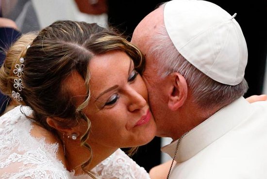 A newly married woman wearing her wedding dress kisses Pope Francis during his general audience in Paul VI hall at the Vatican Nov. 30. CNS photo/Paul Haring