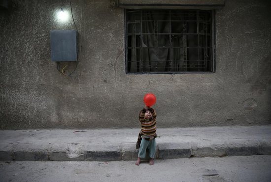 A child plays with a balloon in Douma, Syria Nov. 13. Pope Francis has called events unfolding in the war-torn country a veritable "workshop of cruelty." CNS photo/Bassam Khabieh, Reuters