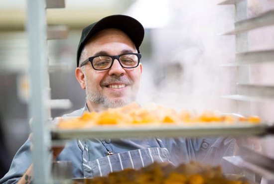 Executive chef Chris Hoffman looks over trays of steaming sweet potatoes in the kitchen of the Society of St. Vincent de Paul in Phoenix Nov. 17. Society staff and volunteers prepare 4,500 meals a day and will do more for Thanksgiving and Christmas. CNS photo/Nancy Wiechec