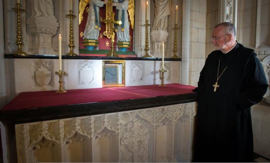 Benedictine Abbot David Charlesworth of England's Buckfast Abbey looks the encased hair shirt worn by St. Thomas More. The shirt is now on permanent display at the abbey. CNS photo/Luke Michael Davies, courtesy Buckfast Abbey Media Studios