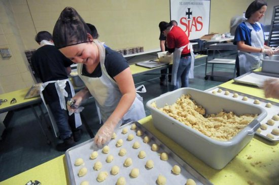 Gabby Orton, a fifth-grader at St. John's Area Catholic School in Foley, Minn., lines up scoops of dough on a pan Nov. 29 for the school's annual cookie fundraiser. CNS photo/Dianne Towalski, The Visitor