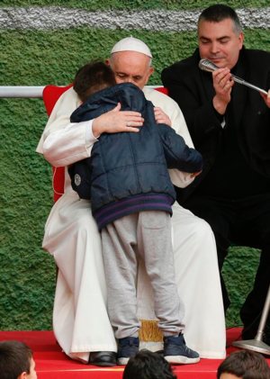 Pope Francis embraces Emanuele, a boy whose father died