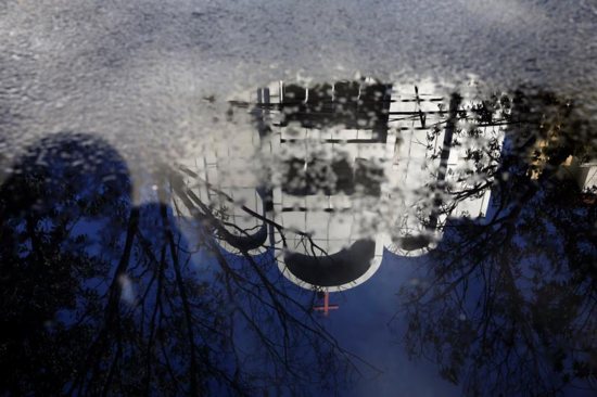 The reflection of a church struck by suicide bombers is seen in Surabaya, Indonesia