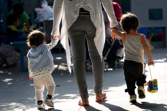 A woman walks with children at a shelter for migrant women and children in Tijuana, Mexico
