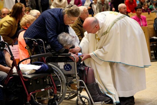 A priest blesses an elderly woman in 2017 at the Knock Shrine in Ireland.