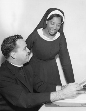 An African-American woman religious consults with a priest in an undated photo at the National Black Sisters' Conference headquarters in Washington.