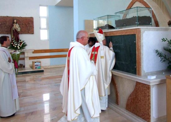 Bishop Petru Gherghel of Iasi, Romania, blesses the tomb of Veronica Antal Sept. 23, the day she was beatified in Nisiporesti, Romania. The 22-year-old was beatified as a "martyr to chastity," six decades after she was murdered while resisting rape.