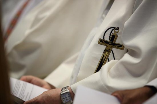 A cross is seen on the stole of an Oblate priest during Mass in late July at Notre-Dame-du-Cap Basilica in Quebec.