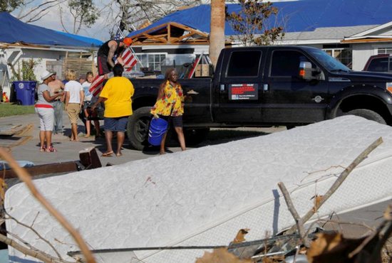 Taylor Fontenot, president of 50 Star Search and Rescue, distributes hot food prepared by Operation BBQ Relief in the aftermath of Hurricane Michael
