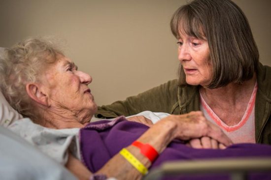 A woman sits at the bedside of her mother in 2016 at de Greeff Hospice house in St. Louis. This special house, the only one of its kind in St. Louis, serves terminally ill individuals.