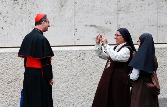A nun takes a video of Cardinal Sergio da Rocha of Brasilia, Brazil, relator of the Synod of Bishops on young people, the faith and vocational discernment, after a synod session at the Vatican Oct 5.