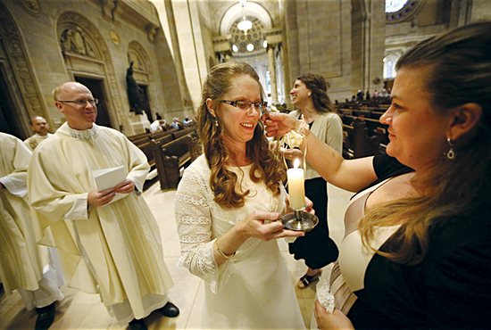 Susan Spiegelberg holds a candle she received during her consecration Mass June 8 at the Cathedral of St. Paul in St. Paul. 